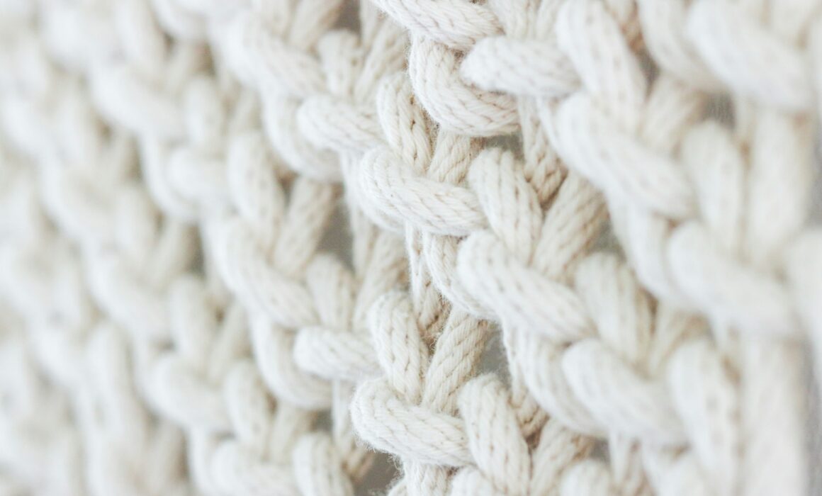 Close-up of soft, intertwined cream-colored threads symbolizing connection and collaboration