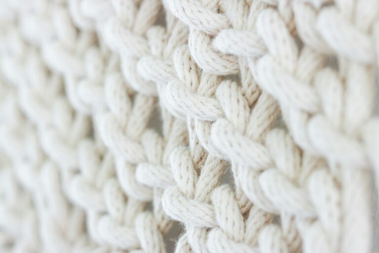 Close-up of soft, intertwined cream-colored threads symbolizing connection and collaboration