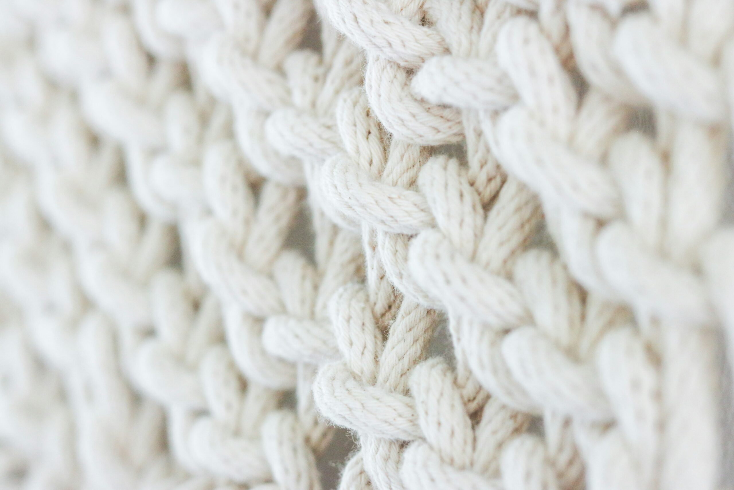 Close-up of soft, intertwined cream-colored threads symbolizing connection and collaboration